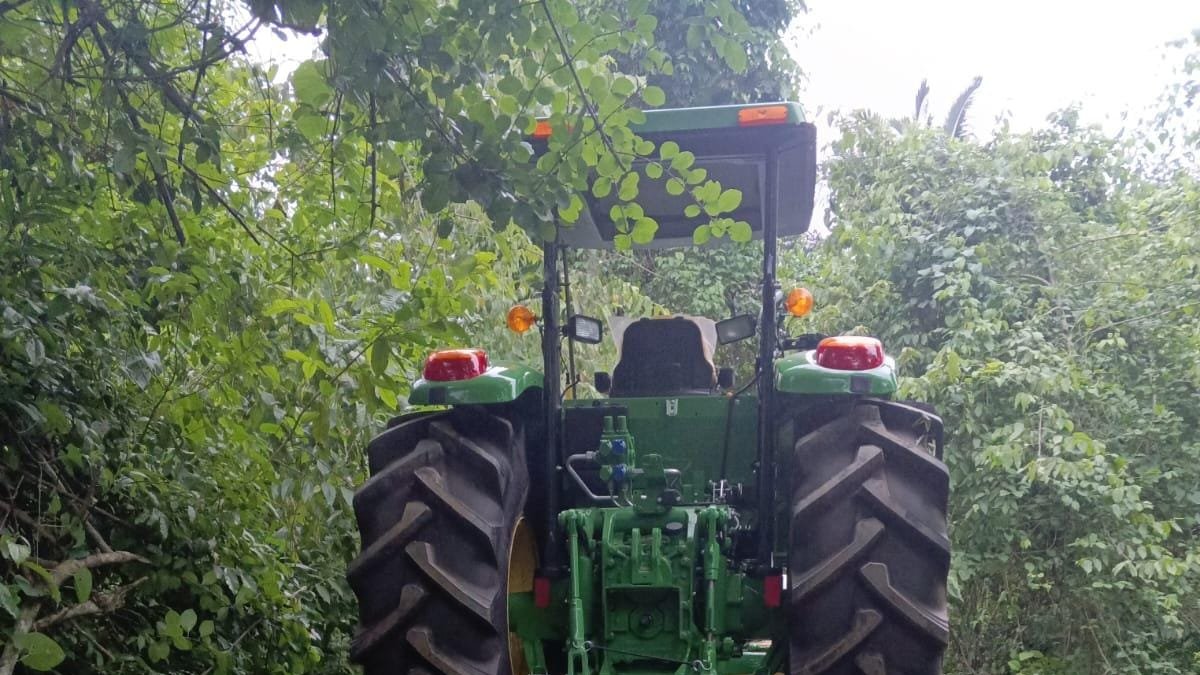 El automotor agrícola recuperado junto a los trabajadores.
