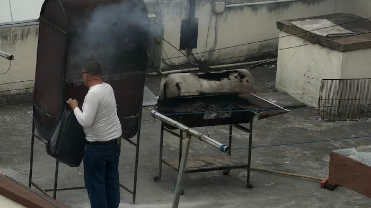 Hombre quema papeles en la terraza de la Embajada de Cuba en Quito.