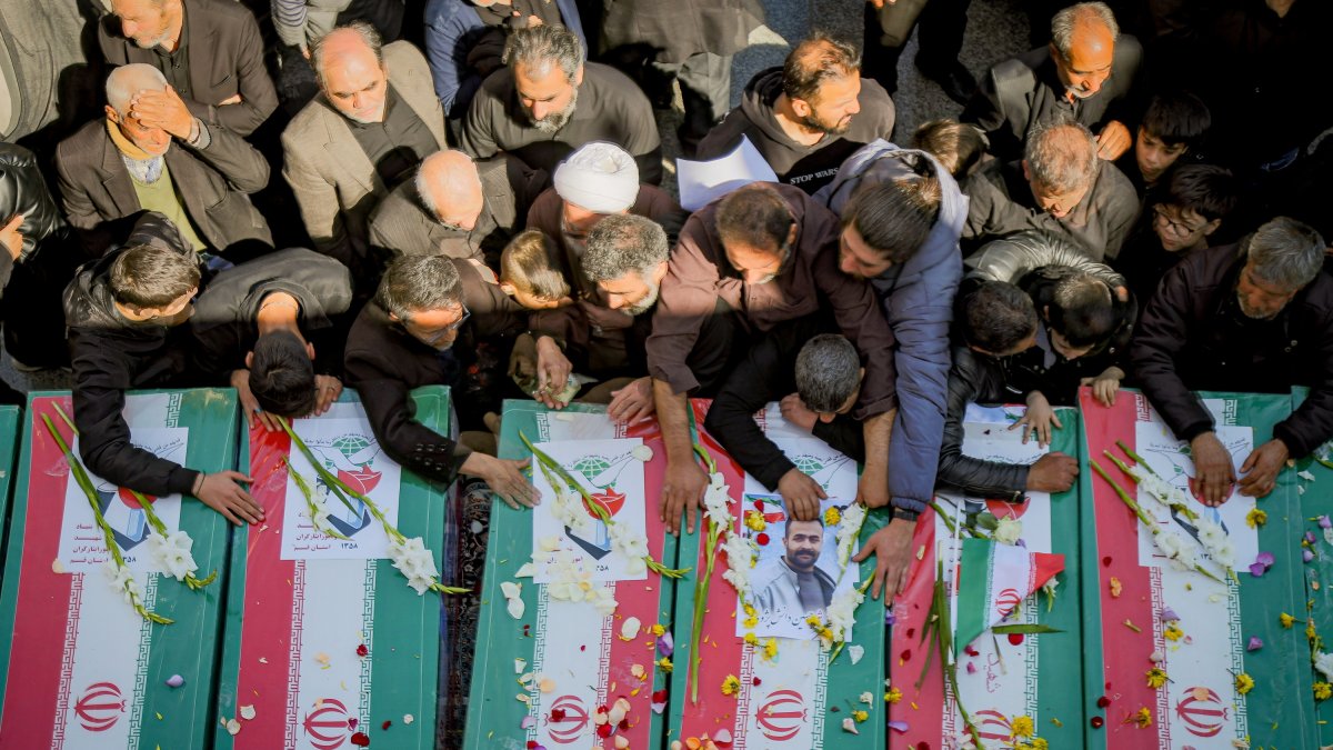 Los familiares lloran junto a los ataúdes de sus seres queridos que murieron en Irán.