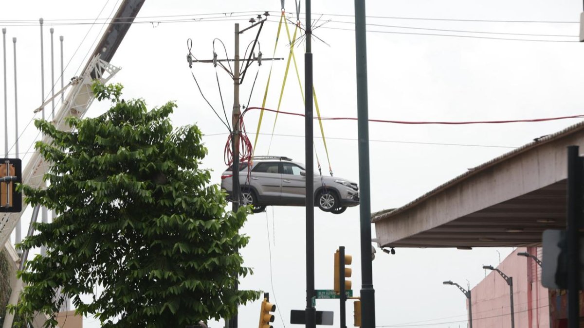 Grúas retiran vehículos atrapados tras el incendio en el edificio Multicomercio de Guayaquil.
