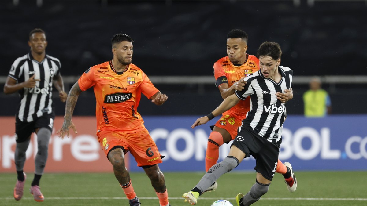 Byron Castillo (c) intenta retener a un rival entre Barcelona y Botafogo.