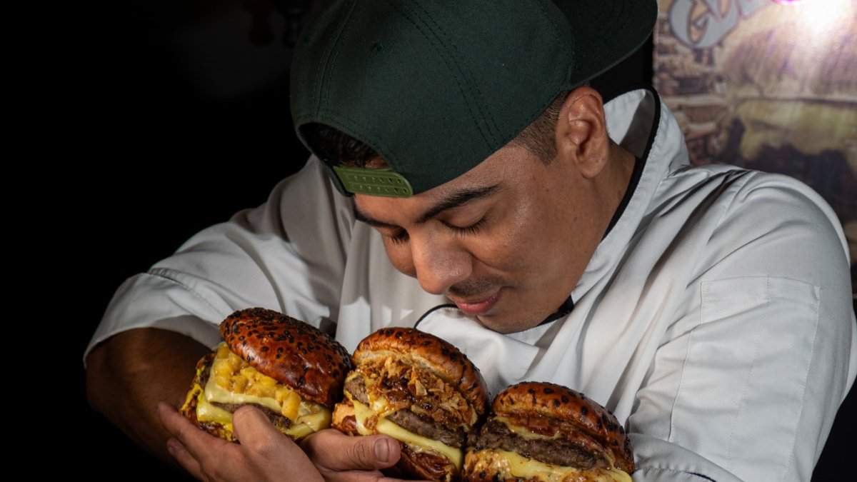 Julio Charco mientras abraza sus creaciones: hamburguesas de autor.