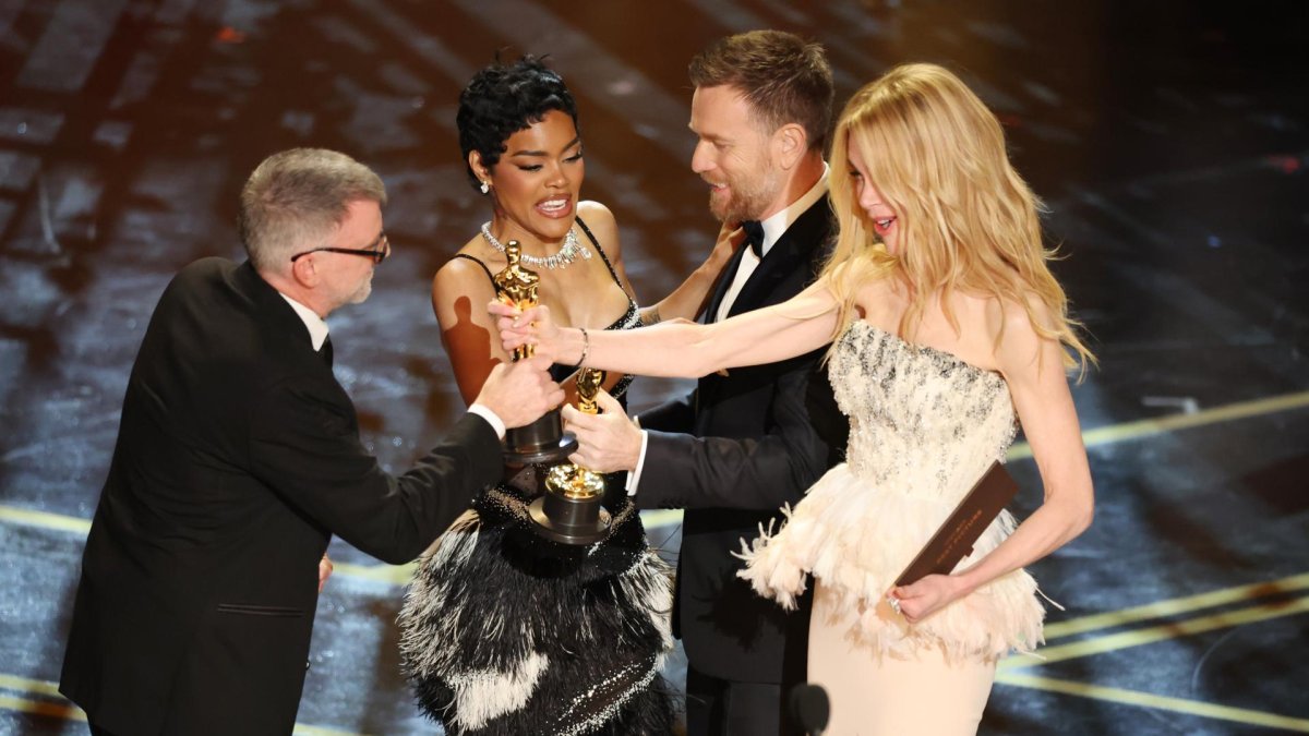 Paul Thomas Anderson (izq.) y Teyana Taylor (segunda desde la izquierda) reciben el Óscar a la mejor película por 