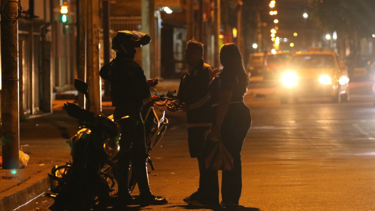 Un integrante de la Policía de Ecuador conversa con ciudadanos tras el toque de queda este domingo, en Guayaquil (Ecuador).