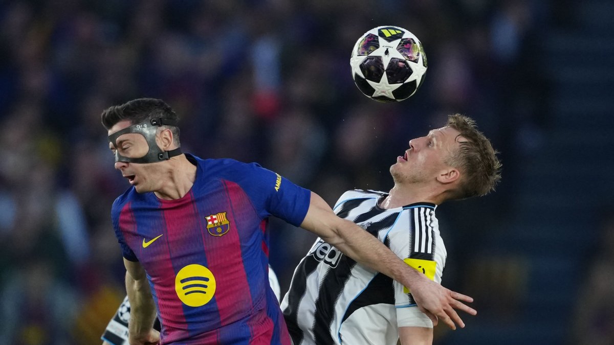 El delantero del FC Barcelona Robert Lewandowski (i) pelea un balón con el defensa del Newcastle Dan Burn.