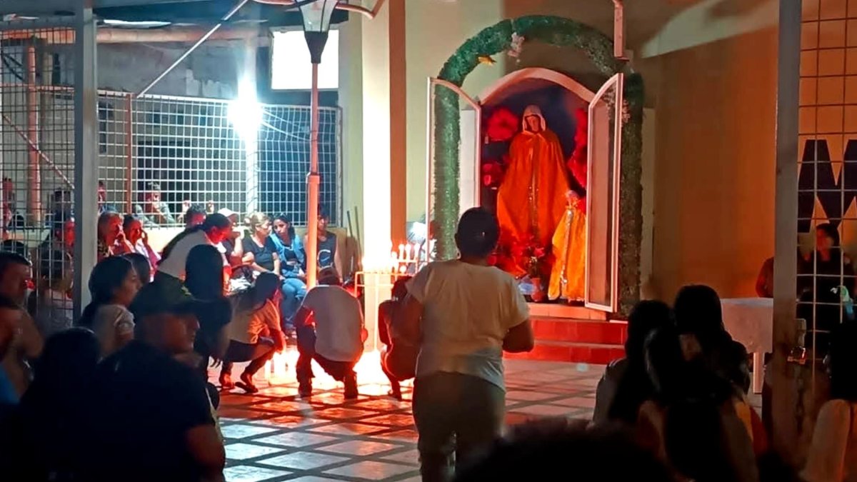 Familiares se congregan frente a la gruta de la Virgen para encender velas y orar por sus desaparecidos.