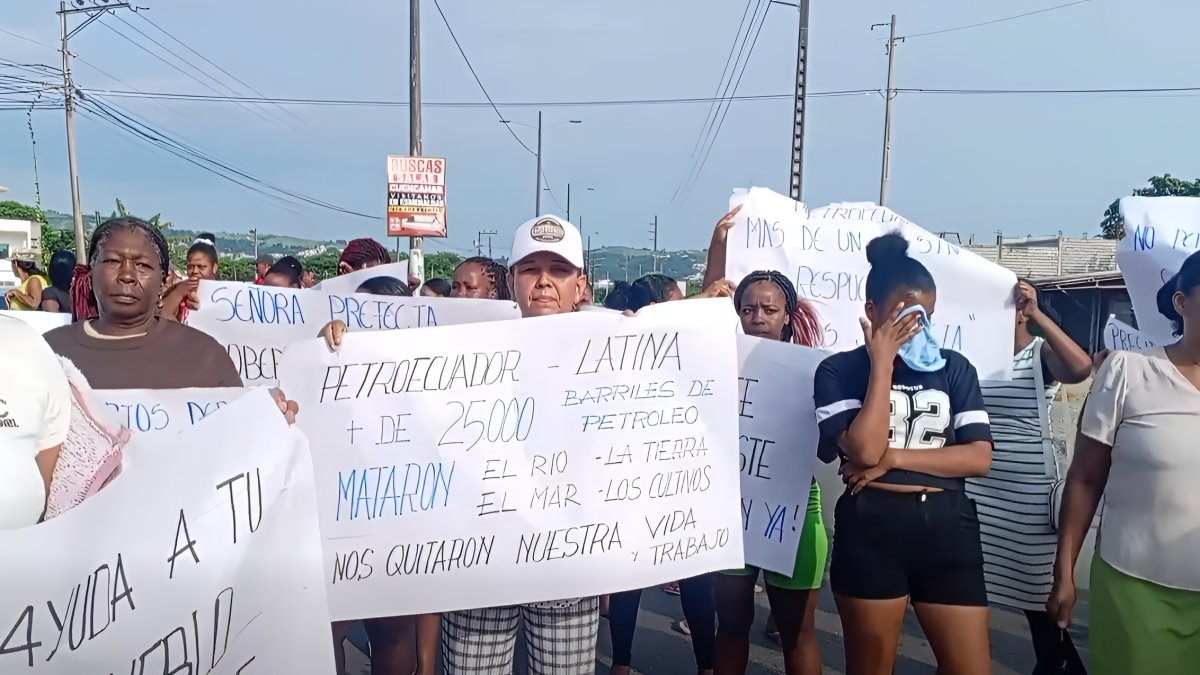 Manifestantes en Esmeraldas exhiben carteles durante la protesta por el derrame de crudo en Quinindé, reclamando indemnizaciones y reparación por los daños ambientales.