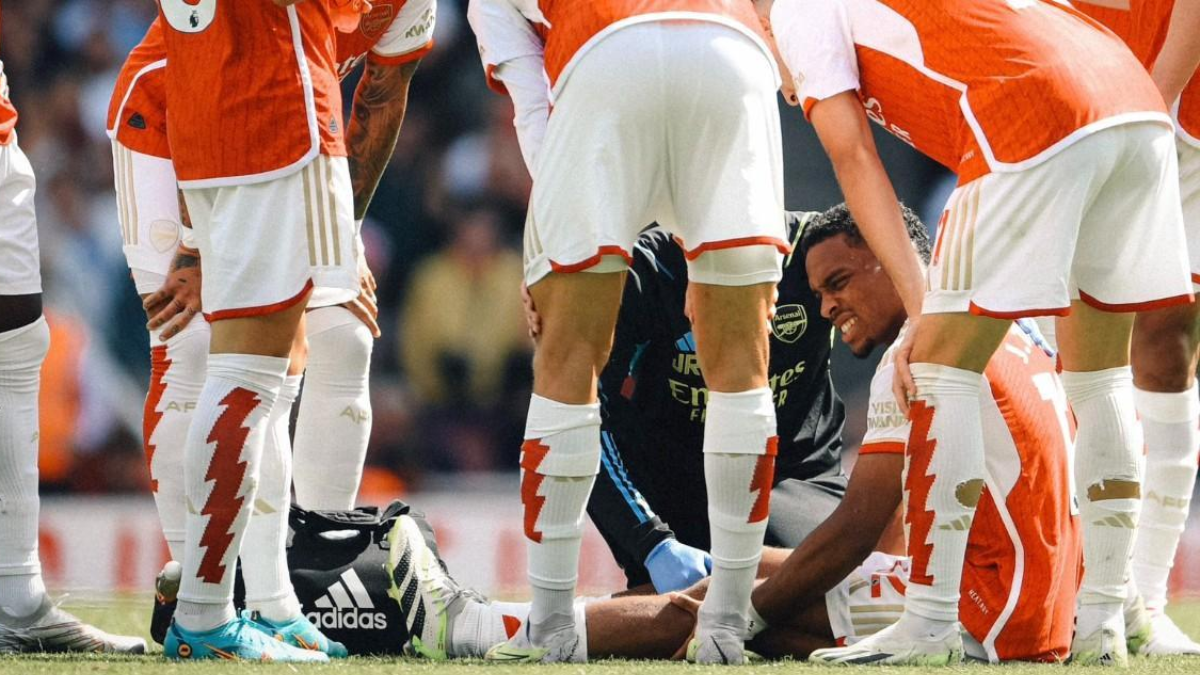 Jurriën Timber se toca la pierna con claros gestos de dolor mientras es atendido por el cuerpo médico del Arsenal