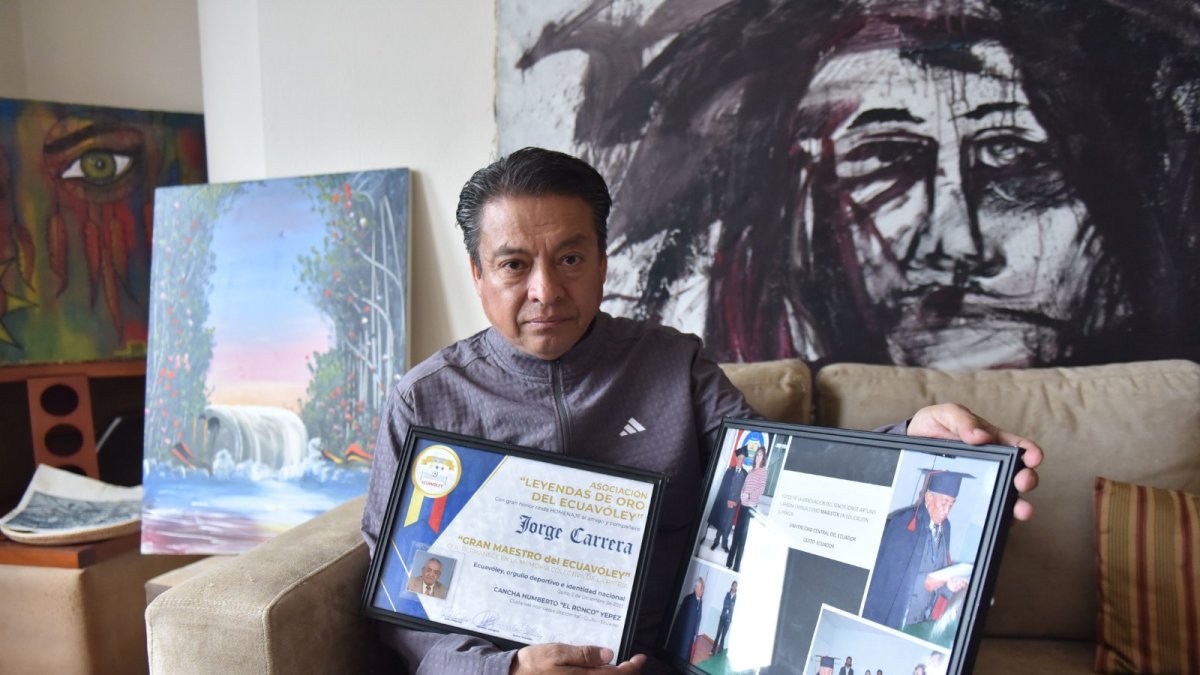 Jonnathan Carrera con varias fotos y placas de los reconocimientos que recibió su padre por el aporte para dar identidad, normativa y masificación del ecuavóley