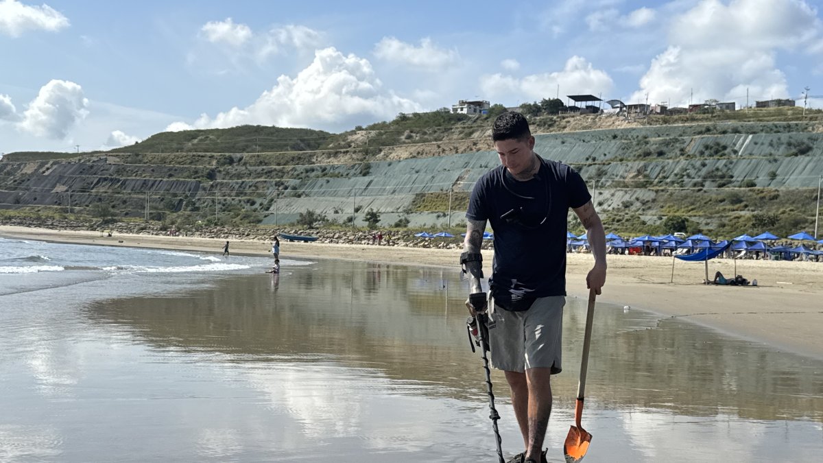 Bryan Zambrano mientras recorre la playa de San Mateo, en Manta, en busca de objetos de valor que quedan enterrados tras la marea.