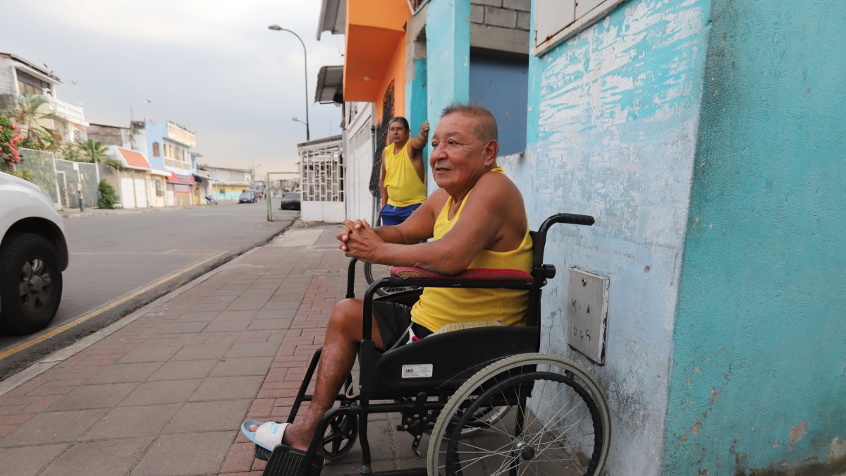 La vereda afuera de su casa se ha convertido en su refugio para escapar del encierro y la tristeza.