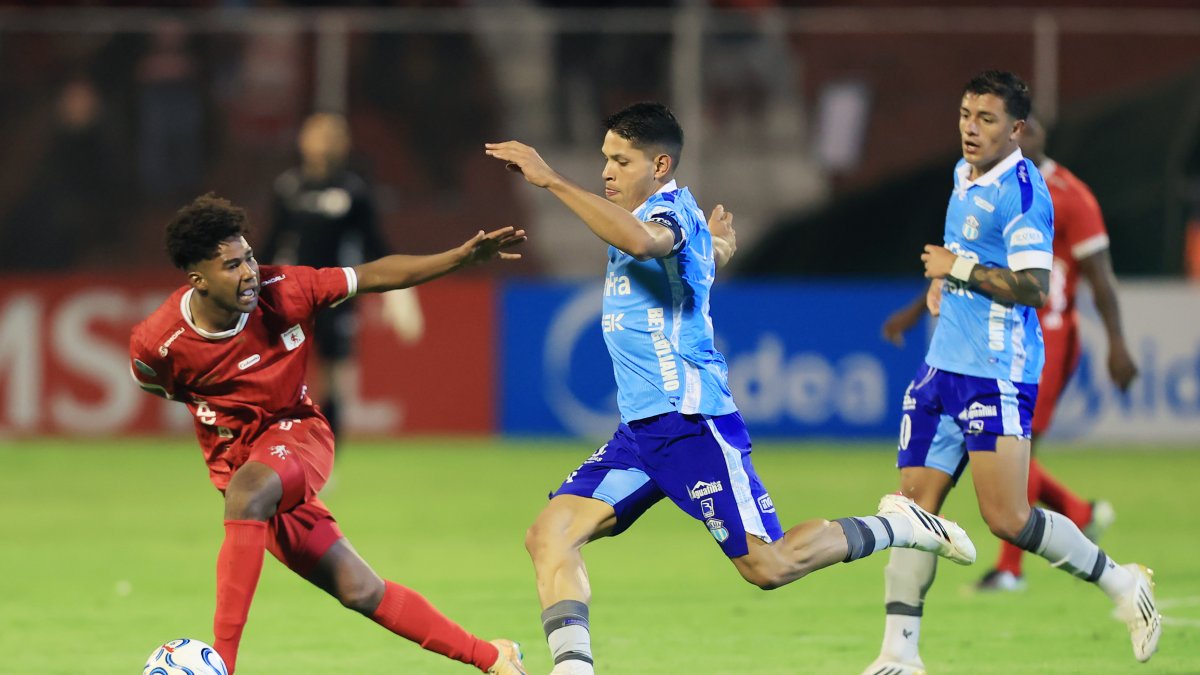 José Marrufo (c) de Macará disputa un balón con Jorge Valencia (i) de América .