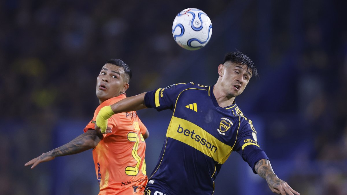 Adam Bareiro (d) de Boca disputa el balón con Matías Lugo de Barcelona.