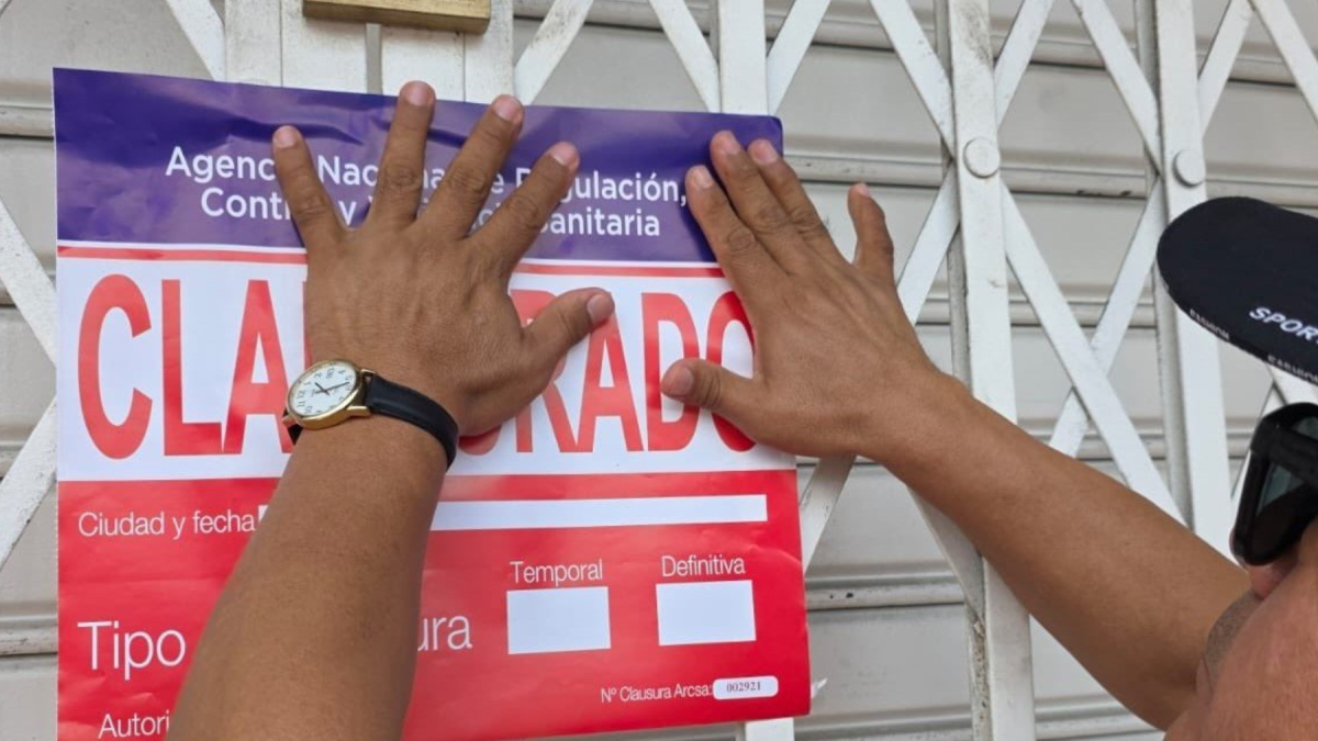 Imagen referencial. Funcionario colocando sello de clausura en un local comercial.