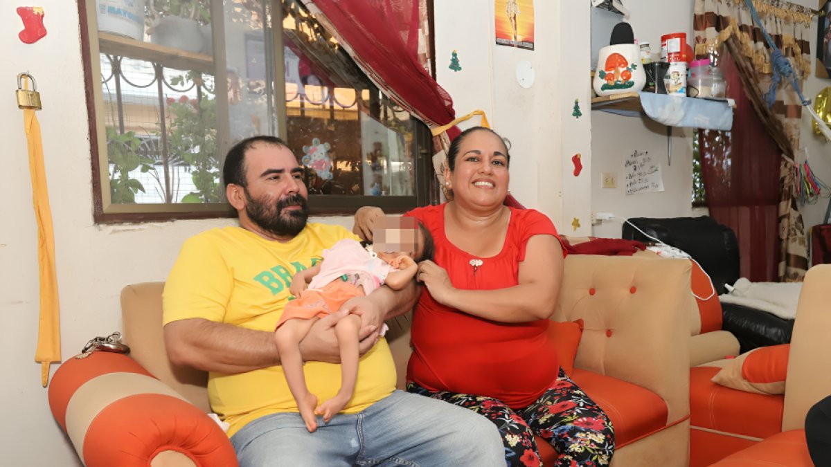 Álex Pérez y Alexandra Carchipulla cargan a Milagro, como a un bebé, en su casa en el sur de Guayaquil.