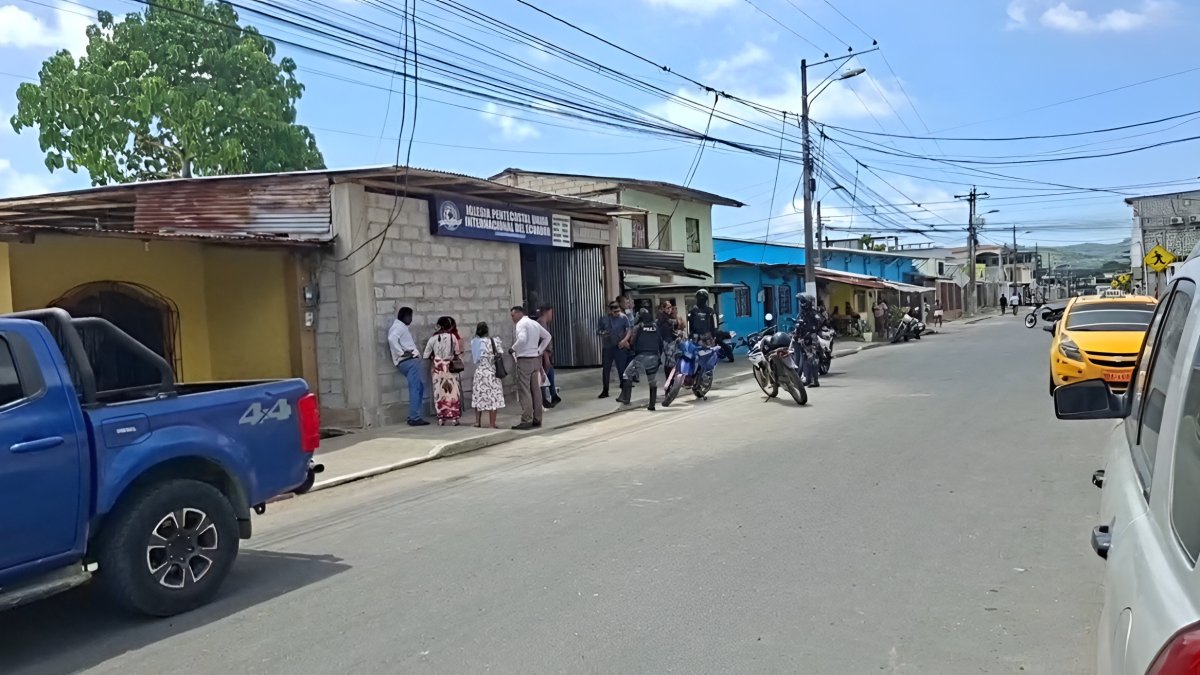 Agentes policiales y ciudadanos permanecen en los exteriores de la iglesia evangélica, tras el asesinato de Henry Paúl Chila Mera.