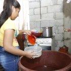  Imagen referencial. Mujer recolecta agua en un tanque para cocina.  