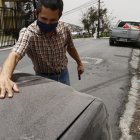 Un ciudadano de Guayaquil retira las cenizas del volcán en un barrio de Guayaquil.