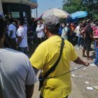 Con una soga se separan a los asistentes que pugnan por entrar a participar en la aparente inversora de fondos.