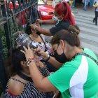 Las mujeres atienden a las usuarias en el bordillo del parterre central de la avenida Olmedo, en la esquina de Chile.