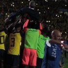 Gustavo Alfaro levantado por los jugadores de Ecuador.