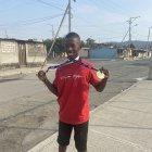 Jorge Quiñónez en las calles de Socio Vivienda 2, mostrando las medallas que va logrando en el atletismo adaptado.