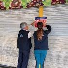 Funcionarios de Arcsa colocando la calcomanía de clausurado en uno de los cinco restaurantes