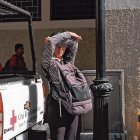 Los peatones se cubren con lo que pueden del cegador resplandor vespertino.