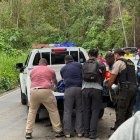 Agentes de la Policía Nacional y moradores del sector colaboran en el traslado de un herido hacia una patrulla, tras el enfrentamiento en Tabiazo, Esmeraldas.