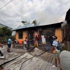 Vecinos de la parroquia Montalvo intentan sofocar las llamas con mangueras mientras un incendio consume una vivienda en Rioverde, Esmeraldas.