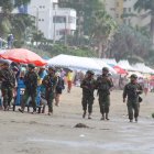 Militares de la Armada del Ecuador patrullan las playas de Atacames durante el feriado de Semana Santa, en medio de turistas y comerciantes, para reforzar la seguridad en el balneario.