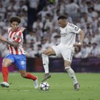 El delantero del Real Madrid Kylian Mbappé (d) juega un balón ante Axel Witsel.