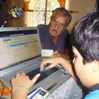 Alfonso Idrovo comprueba, con ayuda de su nieto, los datos que se revelan en la pantalla de la computadora, en la página del Isspol.