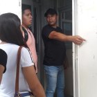  Un trabajador de la universidad muestra a varios estudiantes un cartel con información sobre los cursos. 