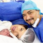 Los felices padres junto a su bebé.