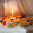 La mesa de los difuntos lleva manteles blancos y platillos como seco de gallina, natilla, bollo, pan de muerto...