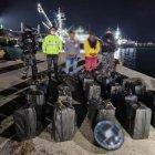 Los dos detenidos y la droga aparecen junto a agentes antinarcóticos.