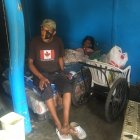 Fabricio Espinoza sentado en un extremo de la cama donde Dora Herrera pasa sus días, a veces sin comer.