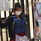 Pilar Reyes, una humilde mujer quechua, protesta atando sus manos con cinta adhesiva a la reja del Tribunal Departamental de Justicia de Cochabamba.