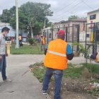 Moradores y policías limpian las aceras de un parque en el Guasmo sur de Guayaquil.