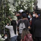 Transeúntes se apuraban para coger los arreglos florales.