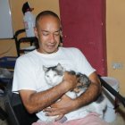 Héctor acaricia a Michuchi, el felino que llegó hasta su casa y desde entonces no se separan.