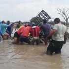 Personas tratan de remolcar el camión con ayuda de una cadena, para sacar a la víctima.
