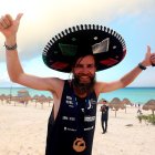 El atleta Jonas Deichmann celebra su llegada hoy, a la zona turística del balneario de Cancún, en el estado de Quintana Roo (México).