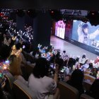 Fans de las superestrellas del K-Pop, BTS, viendo un vídeo del grupo en un evento.