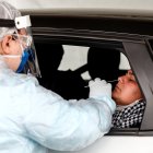 Un trabajador sanitario muestra una prueba de diagnóstico de COVID-19, cuya demanda ha crecido por la presencia de la variante ómicron.