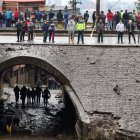 Rescatistas y decenas de moradores miran el desastre causado por el aluvión el 31 de enero.