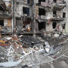 Un miembro de los servicios de emergencia evalúa los daños ocasionados por los bombardeos rusos sobre una zona residencial de Kiev.