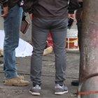 Agentes de Criminalística rodean el cuerpo del hombre asesinado junto a su negocio.