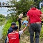 Policías y bomberos en pleno rescate del cuerpo del hombre.